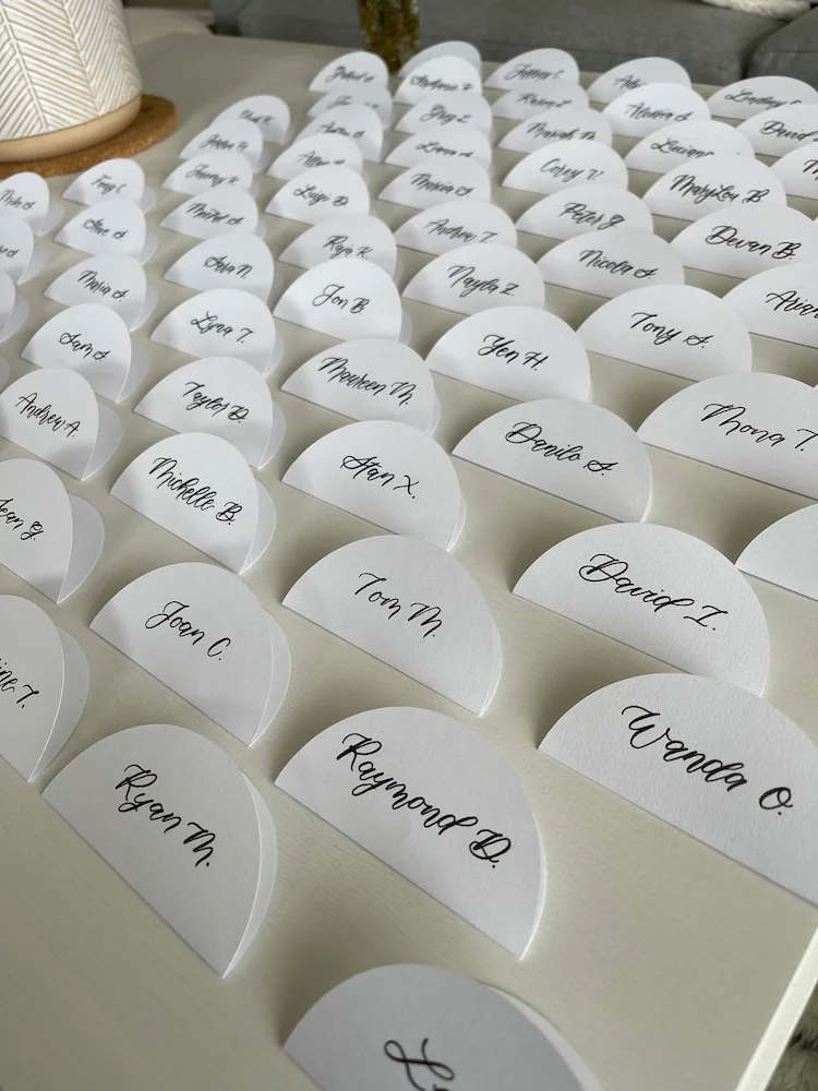 Rows of handwritten place cards arranged on a table